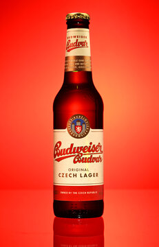 A Budweiser bottle of beer is shown in a red background