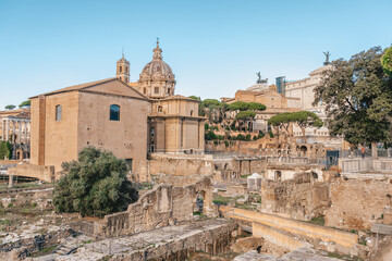 Naklejka premium Panoramic View Of The Roman Forum. Ancient ruins, stone columns, historic landmarks bathed in warm sunlight.