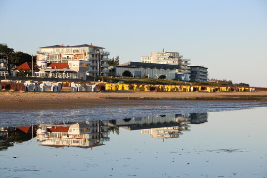 Cuxhaven Duhnen mit Ahoi Schwimmbad spiegelt sich im Wasser der Nordsee bei ablaufendem Wasser 