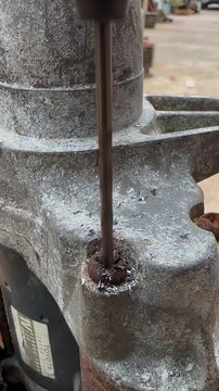 Close up of corroded metal machinery with rusted bolt in heavy industrial equipment showing wear oxidation and mechanical maintenance issues in a factory workshop engineering setting