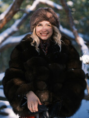 Smiling woman in luxury fur hat. Slavic style winter fashion portrait