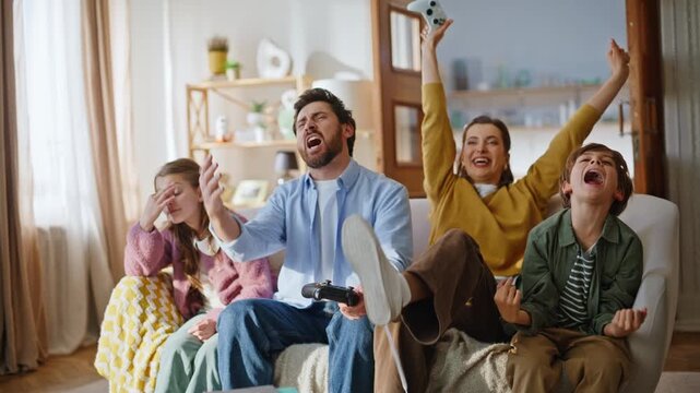 Mother son celebrating online win playing video game with father daughter room