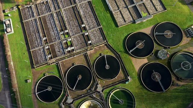 Top down aerial view of circular clarifying tanks and aeration basins, aerobic digestion and settling ponds for sewage works in the UK