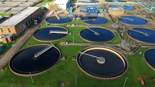 Top down aerial view of circular clarifying tanks and aeration basins, aerobic digestion and settling ponds for sewage works in the UK