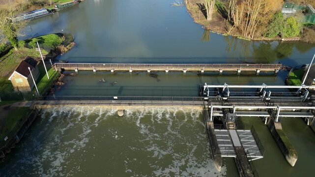 Aerial Drone View of Sluice Gate and River Barrier in Hoddesdon UK, Water Cascading Over Weir and Canal Lock System for Navigation in England 4K