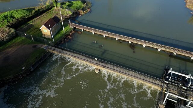 Aerial Drone View of Sluice Gate and River Barrier in Hoddesdon UK, Water Cascading Over Weir and Canal Lock System for Navigation in England 4K