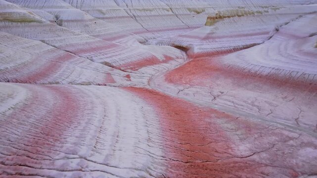 Aerial view of the Aktogay Mountains showcases the stark contrast between the white rock formations and the vibrant pink hues, Karynzharyk, Mangystau Region, Kazakhstan.