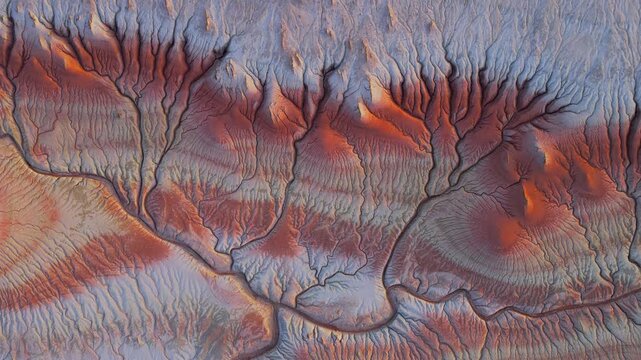 Aerial view of a textured landscape with contrasting red and grey tones creating a unique pattern, Karynzharyk, Mangystau Region, Kazakhstan.