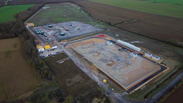 Close up aerial view of 400kV substation featuring supergrid transformers and high voltage pylons for the Great Grid Upgrade near Biggleswade United Kingdom. 