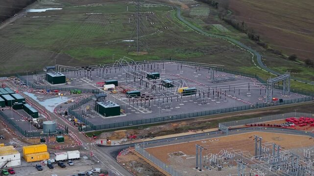Close up aerial view of 400kV substation featuring supergrid transformers and high voltage pylons for the Great Grid Upgrade near Biggleswade United Kingdom. 