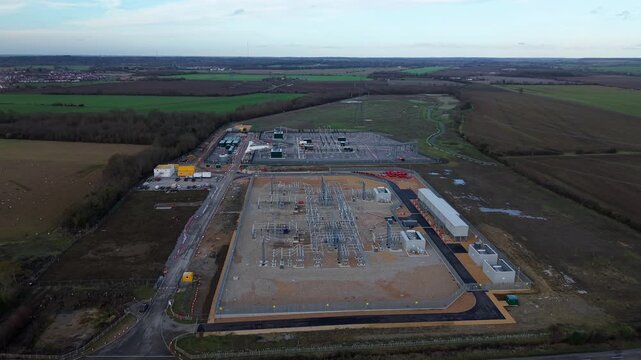 Close up aerial view of 400kV substation featuring supergrid transformers and high voltage pylons for the Great Grid Upgrade near Biggleswade United Kingdom. 