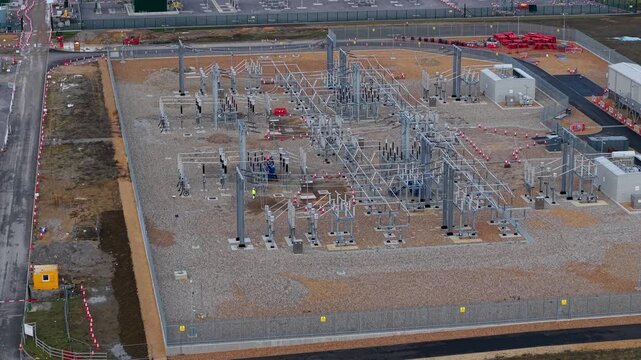 Close up aerial view of 400kV substation featuring supergrid transformers and high voltage pylons for the Great Grid Upgrade near Biggleswade United Kingdom. 