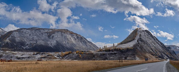 Fototapeta premium Russia. The South of Western Siberia, the Altai Mountains. A fascinating view of the mountains with yellow larches, dusted with the first autumn snow, along the Chuya highway in the valley of the Chuy