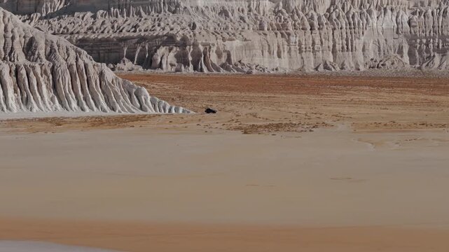 Aerial view of the expansive Tuzbair Sor, where stark white cliffs meet the vast, sun-baked earth, creating a surreal landscape, Tuzbair, Mangystau Region, Kazakhstan.