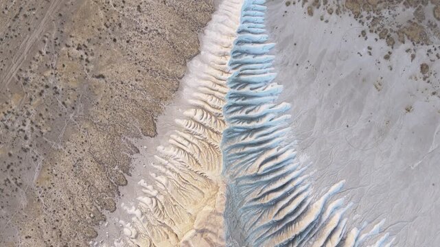 Aerial view of white and beige chalk cliffs, with textures of erosion, creating a striking contrast in the arid landscape, Tuzbair, Mangystau Region, Kazakhstan.