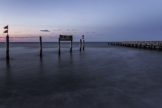 Wooden sign in the sea with inscription Zingst and wooden walkway, long exposure, evening light, Zingst, Fischland-Dar&szlig;-Zingst, Western Pomerania National Park, Mecklenburg-Western Pomerania, Germany