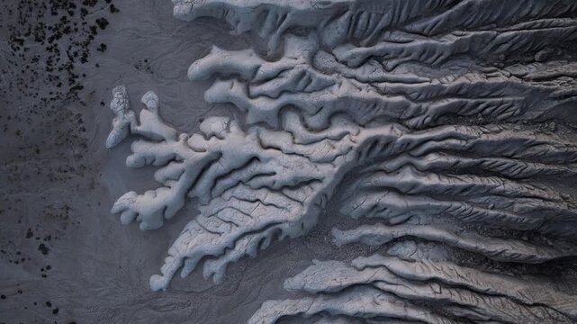Aerial view of the stark, cracked earth, revealing an abstract landscape of ridges and valleys, showcasing the arid beauty of Tuzbair, Mangystau Region, Kazakhstan.