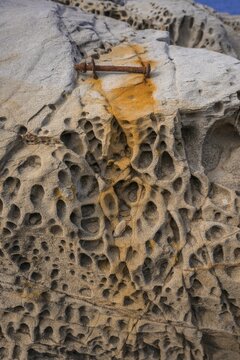 Rusty screw and stone structures in the Buca delle Fate, Populonia, Piombino, Province of Livorno, Italy