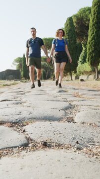 Romantic couple walking along the ancient Appia Antica in Rome