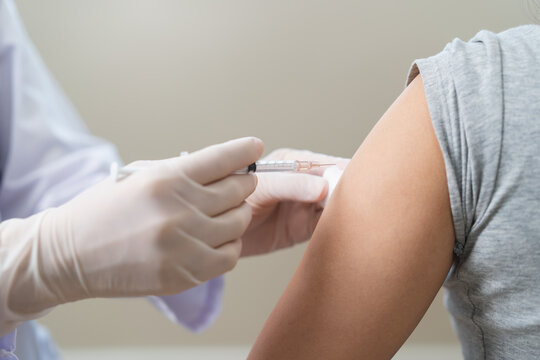 People getting a vaccination to prevent pandemic concept. Woman in medical face mask  receiving a dose of immunization coronavirus vaccine from a nurse at the medical center hospital