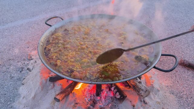 Valencia authentic paella cooking over firewood in paellera pan