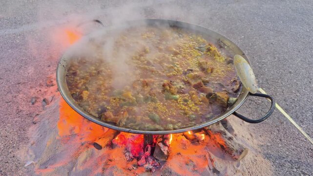 Valencia authentic paella cooking over firewood in paellera pan
