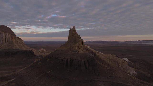 Aerial view of striking rock formations in a vast desert landscape under a cloudy sky, creating a scene of natural wonder, Shetpe, Mangystau Region, Kazakhstan.