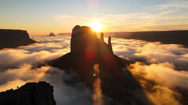 Sweeping aerial drone view gliding slowly above a sea of thick, rolling yellow mist revealing jagged rock formations at sunrise mysterious, ethereal, remote
