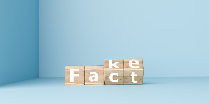 Hand turning wooden cubes from the word Fake to Fact on blue background. Concept for news verification, truth seeking, misinformation, and media literacy in digital age for business and education.