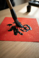AI-generated image - A close-up image of an ancient Chinese calligraphy brush writing the character "Fu" (fortune) on red paper, a symbol of good fortune, Chinese New Year celebrations, and Asian cult