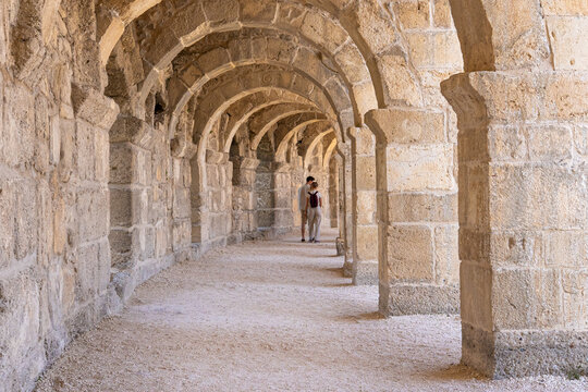 People walking among columns of the ancient Theatre