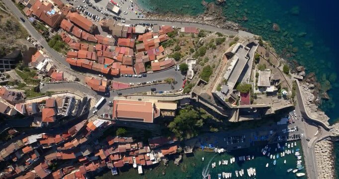 Aerial perpendicular view of the cathedral and the Ruffo Castle located in the historic center of the town of Scilla, Calabria, Italy. It is a village located on a promontory overlooking the sea.