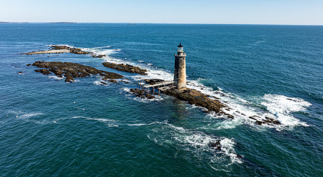Aerial view of Ram Island Ledge Light stands tall amidst the crashing waves, a beacon against the deep blue sea, Portland, Maine, United States.