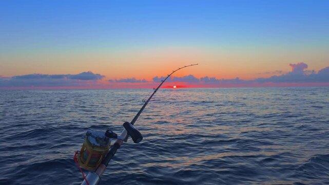 Offshore trolling fishing at sunset with rods on boat in open sea