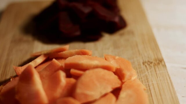 Fresh carrot and beet sliced on a chopping board