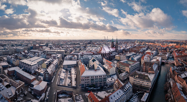 Aerial view of snow-dusted rooftops and the towering spires of St. Lorenz Church pierce the winter sky, Nuremberg, Germany.
