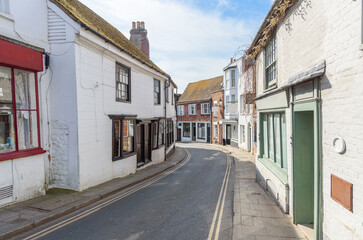 Fototapeta premium Traditional architecture and shops along a deserted street in a historic town centre on a sunny spring day