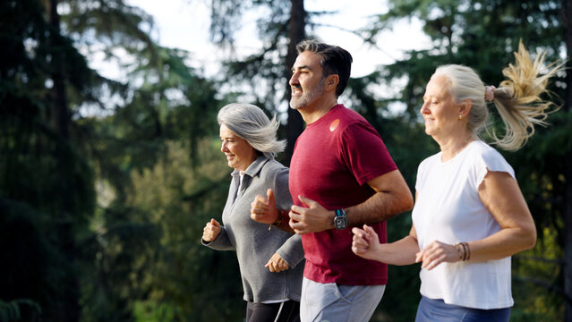 Three senior friends are enjoying a jog in a park, embracing wellness, fitness, and healthy aging outdoors