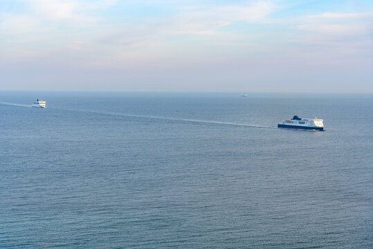 Passenger ferries approaching the coast England near the port of Dover on a misty spring day