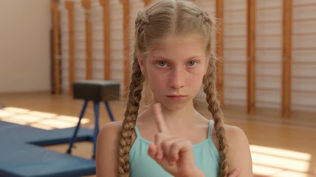 Caucasian sad negative teen girl upset teenager child kid daughter dissatisfied crossed hands offended saying no not acrobat gymnast teenage pupil shaking finger refuse deny reject in school sport gym