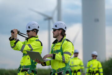 Engineers working on site in wind turbine farm, Wind turbines generate clean energy source, Eco...