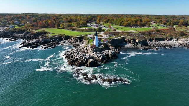 Aerial view of Portland Head Light with its white tower standing tall against the rugged coastline and deep blue sea, Cape Elizabeth, Maine, United States.