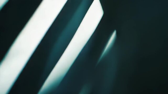 Abstract parallel light streaks creating a dynamic background with a blurred, glowing effect, blending dark teal and white tones for a digital motion aesthetic