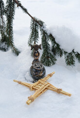 wiccan goddess figurine with crystal ball and straw brigid's cross amulet on snow nature background...