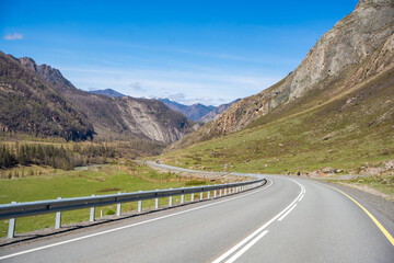 Fototapeta premium Road stretching along the Chuya River on Chuysky Trakt in Altai Russia. Scenic mountain route through wild Siberian landscape.