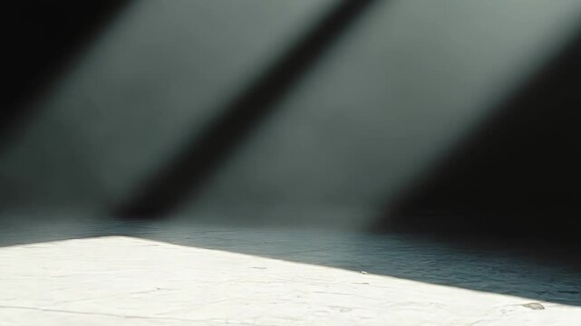 Sunlight beams stream through a dark void, casting striking diagonal shadows and a rectangular patch of bright illumination on a textured concrete surface, creating a minimalist concept background