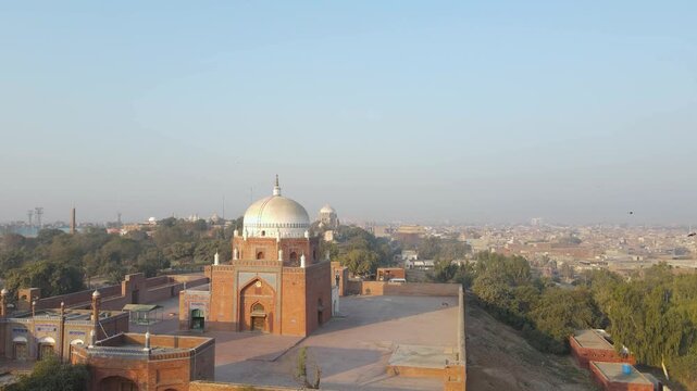 Aerial view of Shrine of Bahauddin Zakariya with its red brickwork and white dome stands out against the backdrop of the city, Multan, Punjab, Pakistan.