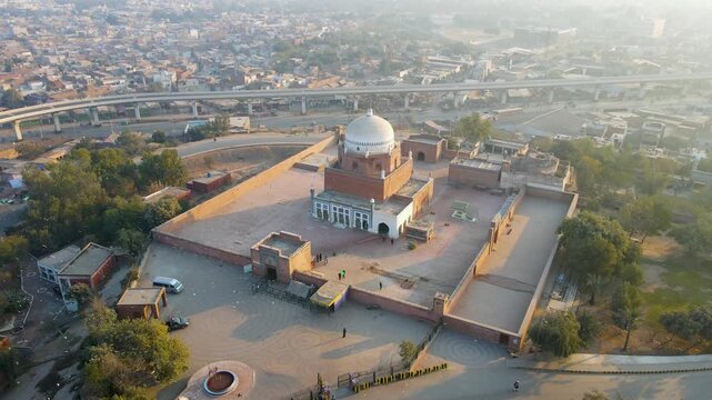 Aerial view of the Shrine of Bahauddin Zakariya, a majestic structure with a white dome contrasted against the surrounding urban landscape, Multan, Punjab, Pakistan.
