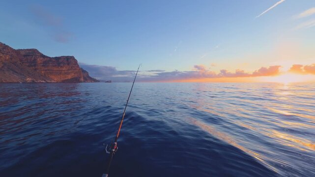 Serra Gelada Benidorm sunrise fishing boat with rod on calm Mediterranean