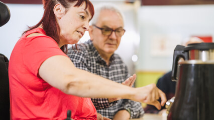 Woman with disability sitting in a wheelchair while learning to operate a smart kitchen appliance...